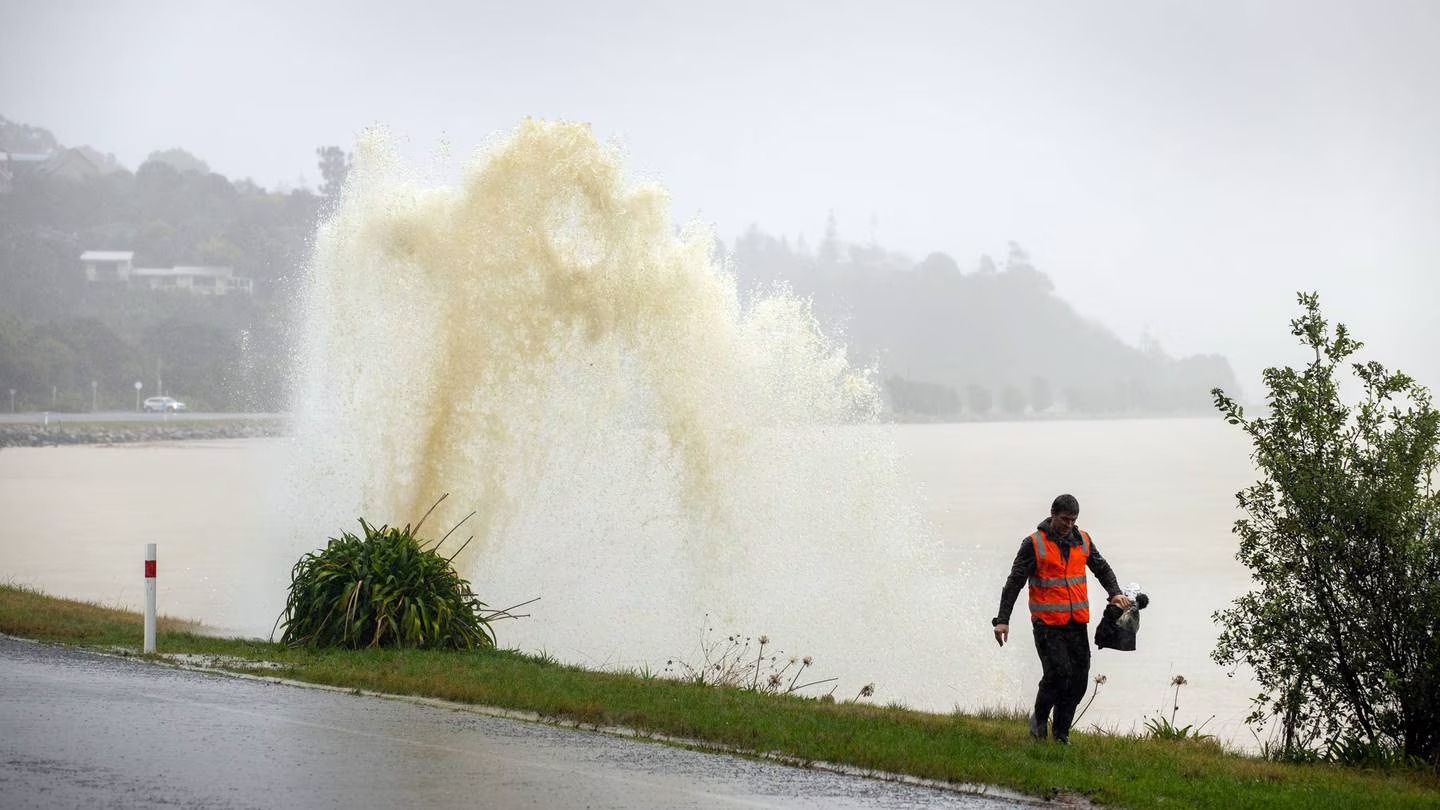 A Nelson resident walks by a broken stormwater pipe during a flood-making rain event last year. Three Waters will oversee drinking water, wastewater and stormwater. Photo / Tim Cuff