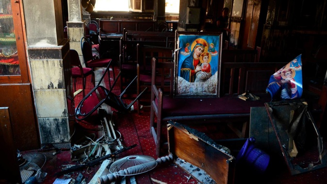 Burned furniture, including wooden tables and chairs, and a religious images at the site of a fire inside the Abu Sefein Coptic church. Photo / Tarek Wajeh, AP