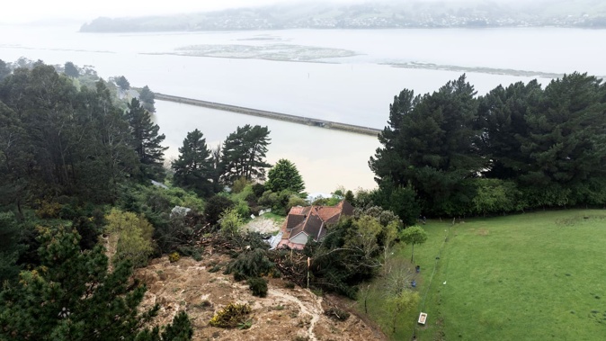 The damage caused by the Dunedin floods includes this massive slip which almost buried a house. Photo / George Heard
