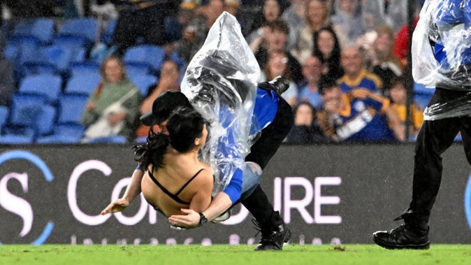 A pitch invader is tackled by a security guard during NRL match. Photo / Getty Images