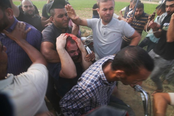 Palestinians transport a captured Israeli civilian (centre), from Kibbutz Kfar Azza into the Gaza Strip on October 7. Photo / AP