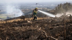 Fire crews fighting the Port Hills fire are scaling back work, with all helicopters and aircraft grounded. Photo / George Heard
