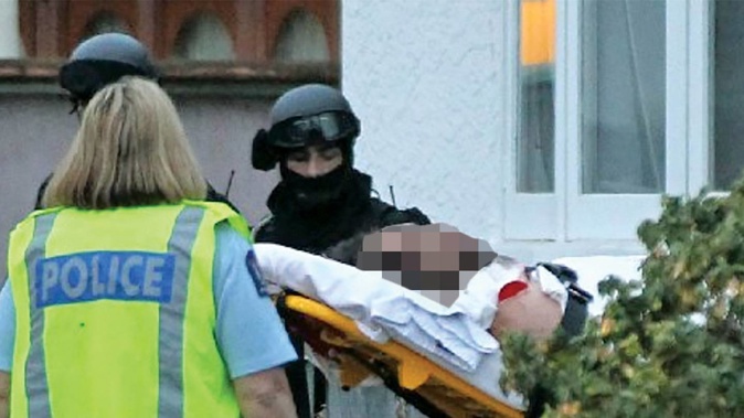 Emergency services tend to Iriheke Pere after he was shot by a member of the Armed Offenders Squad at his Karamu Road home in August 2013. (Photo / Duncan Brown)