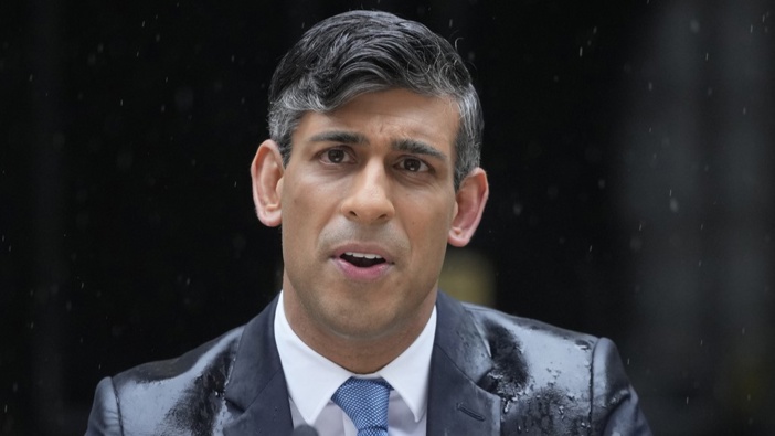 Britain's Prime Minister Rishi Sunak speaks to the media, as heavy rain falls, outside 10 Downing Street in London Wednesday, May 22, 2024, as he announces that he is to call a General Election for July 4. (AP Photo/Kin Cheung)