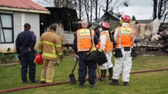 Members of the community affected by the Māngere Bridge fire gather outside to survey the damage. Photo / Ben Dickens