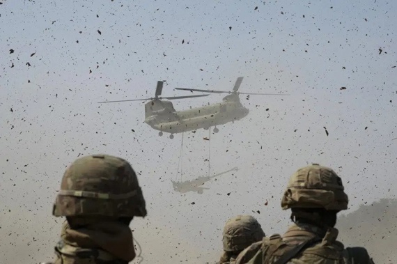 A U.S Army CH-47 Chinook helicopter transports a M777 howitzer during a joint military drill between South Korea and the United States at Rodriguez Live Fire Complex in Pocheon, South Korea, Sunday, March 19, 2023. North Korea launched a short-range ballistic missile toward the sea on Sunday, its neighbors said, ramping up testing activities in response to U.S.-South Korean military drills that it views as an invasion rehearsal. (AP Photo/Ahn Young-joon)