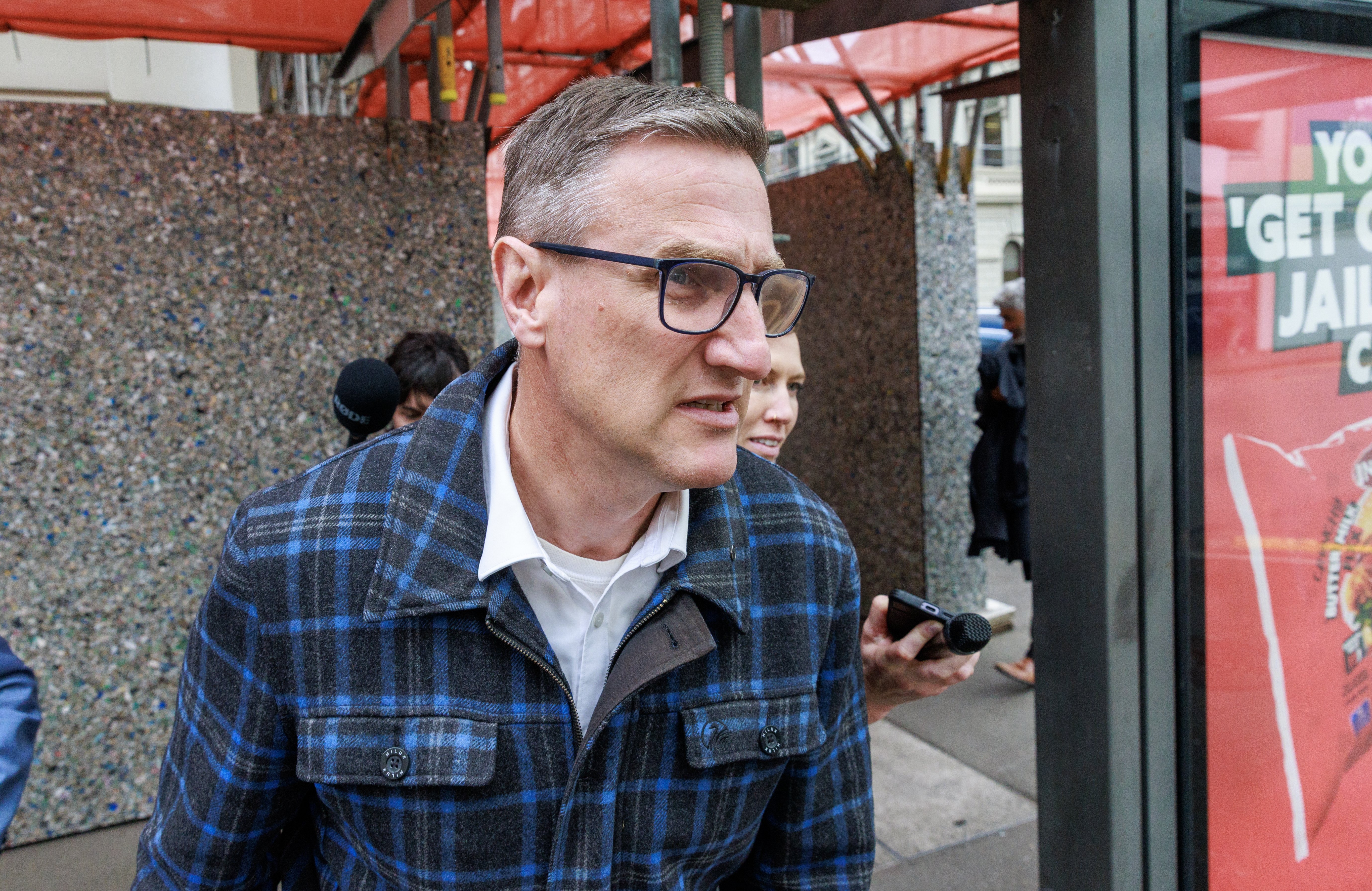 Former Deputy Police Commissioner Jevon McSkimming (wearing glasses) is pursued by media after pleading guilty to eight charges of possessing objectionable publications in the Wellington District Court, Wellington New Zealand, November 06, 2025. Herald photograph by Mark Mitchell