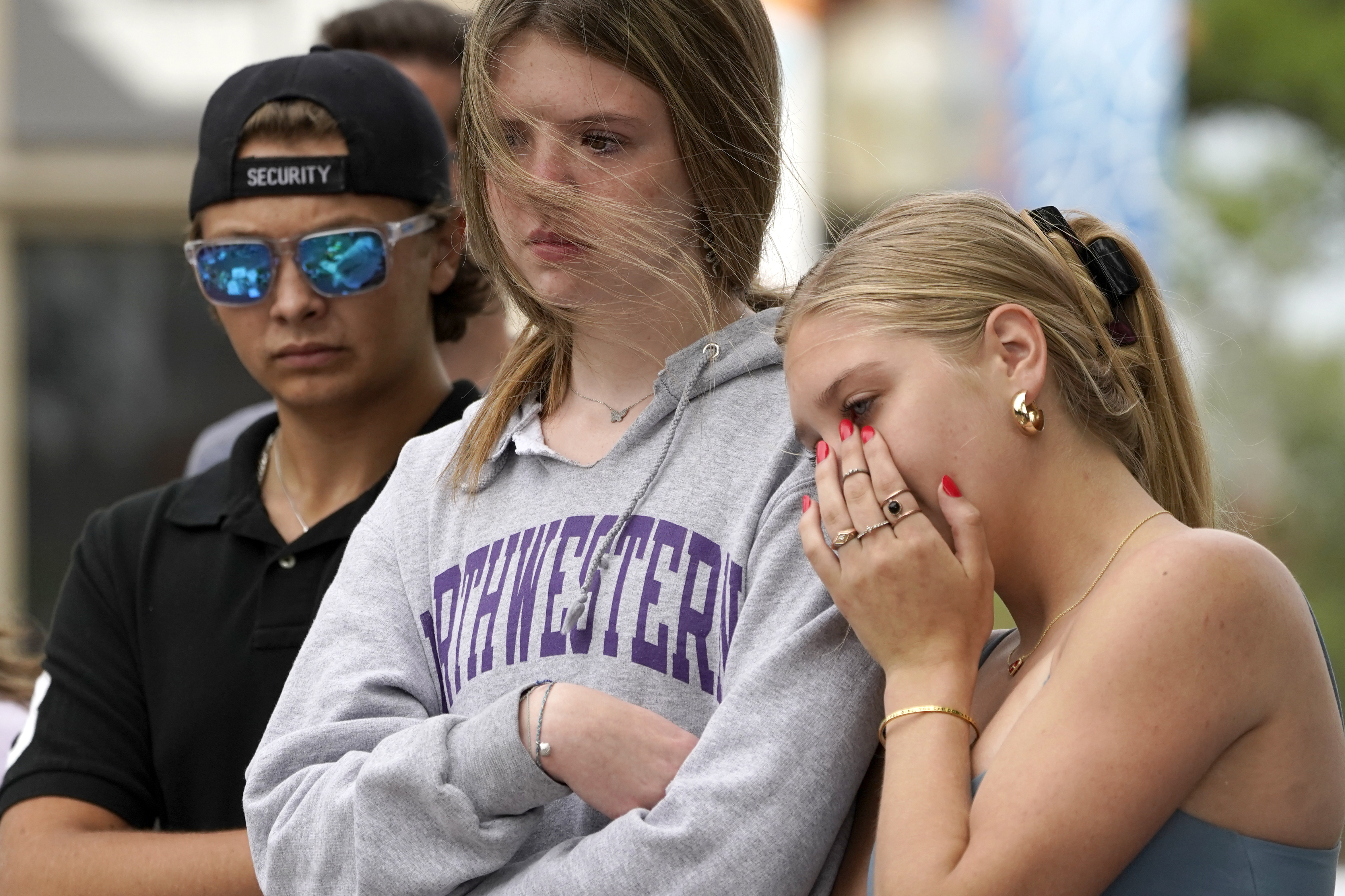 Helena Kavanaugh, right, stands with friends Addison Schwan, center, and Charlie Shookman after Kavanaugh placed flowers at a memorial for the seven people who lost their lives in the Highland Park, Ill., Fourth of July mass shooting. Photo / AP