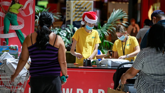 Christmas shopping during a pandemic means Santa hats paired with face masks. (Photo / Alex Burton)