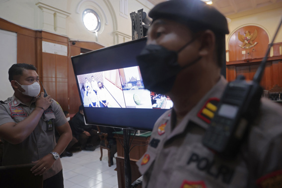 Police officers stand near a monitor inside a court room during a trial in Surabaya, East Java, Indonesia. Photo / AP