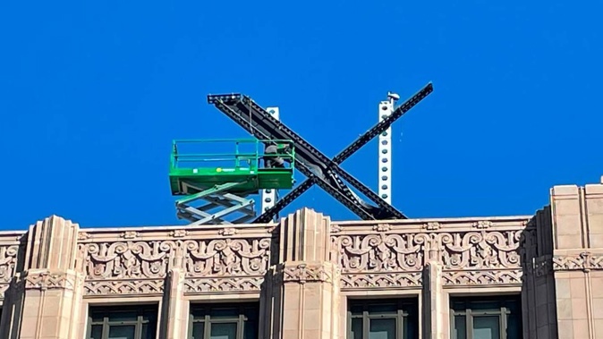 A large, metal X sign on top of the downtown building what was once Twitter. Photo / AP