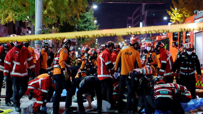 Rescue workers and firefighters work on the scene of a crushing accident in Seoul, South Korea on Saturday. South Korean officials say dozens of people were in cardiac arrest after being crushed by a large crowd pushing forward on a narrow street during Halloween festivities in the capital Seoul. Photo / AP