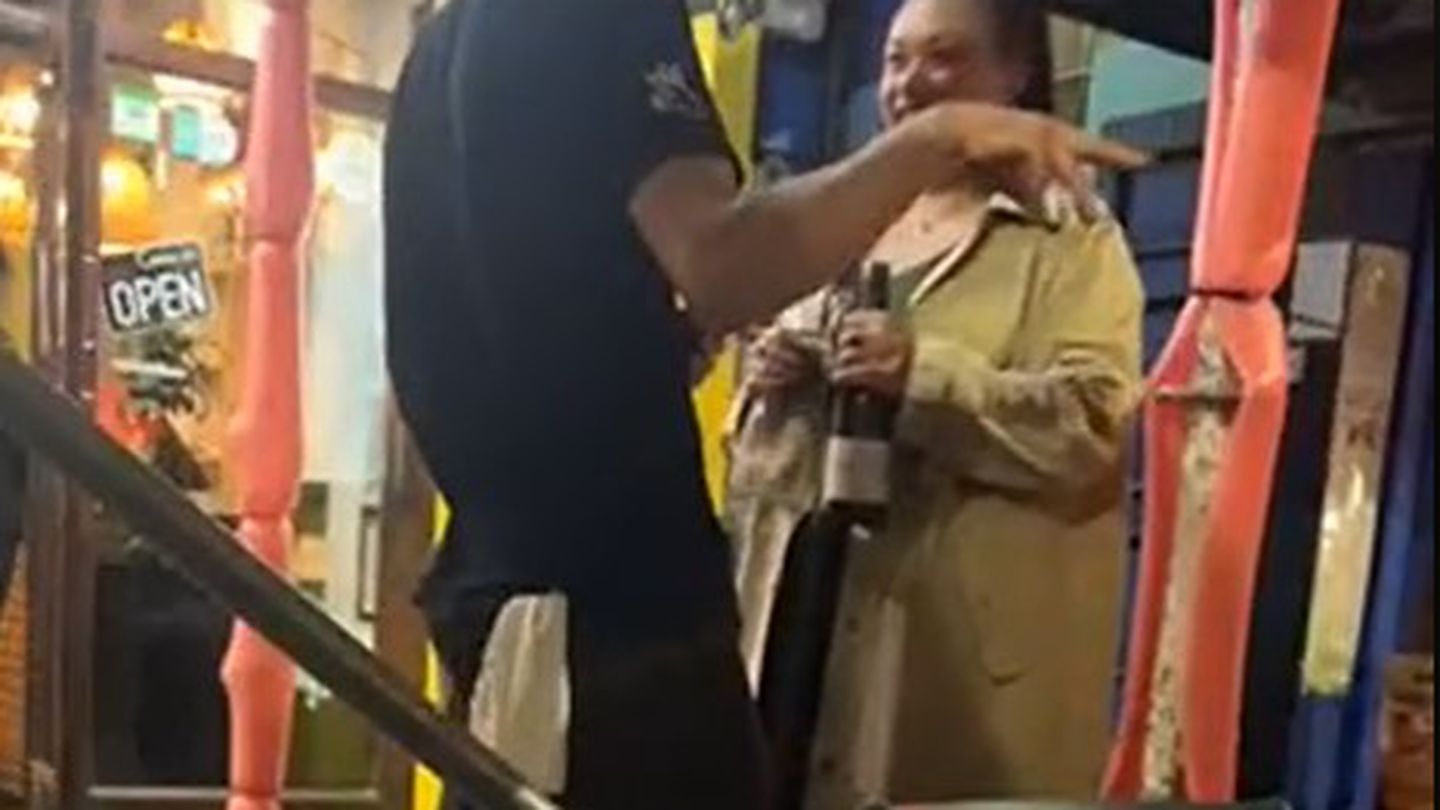 Mayor Tory Whanau holding a bottle of wine, in discussion with a waiter outside The Old Quarter on Friday. Photo / Supplied