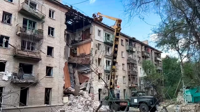 Emergency Ministry employees work at the side of a damaged apartment building following Friday's Ukrainian missile attack on Luhansk, the capital of Russian-controlled Luhansk region, eastern Ukraine. Photo / AP