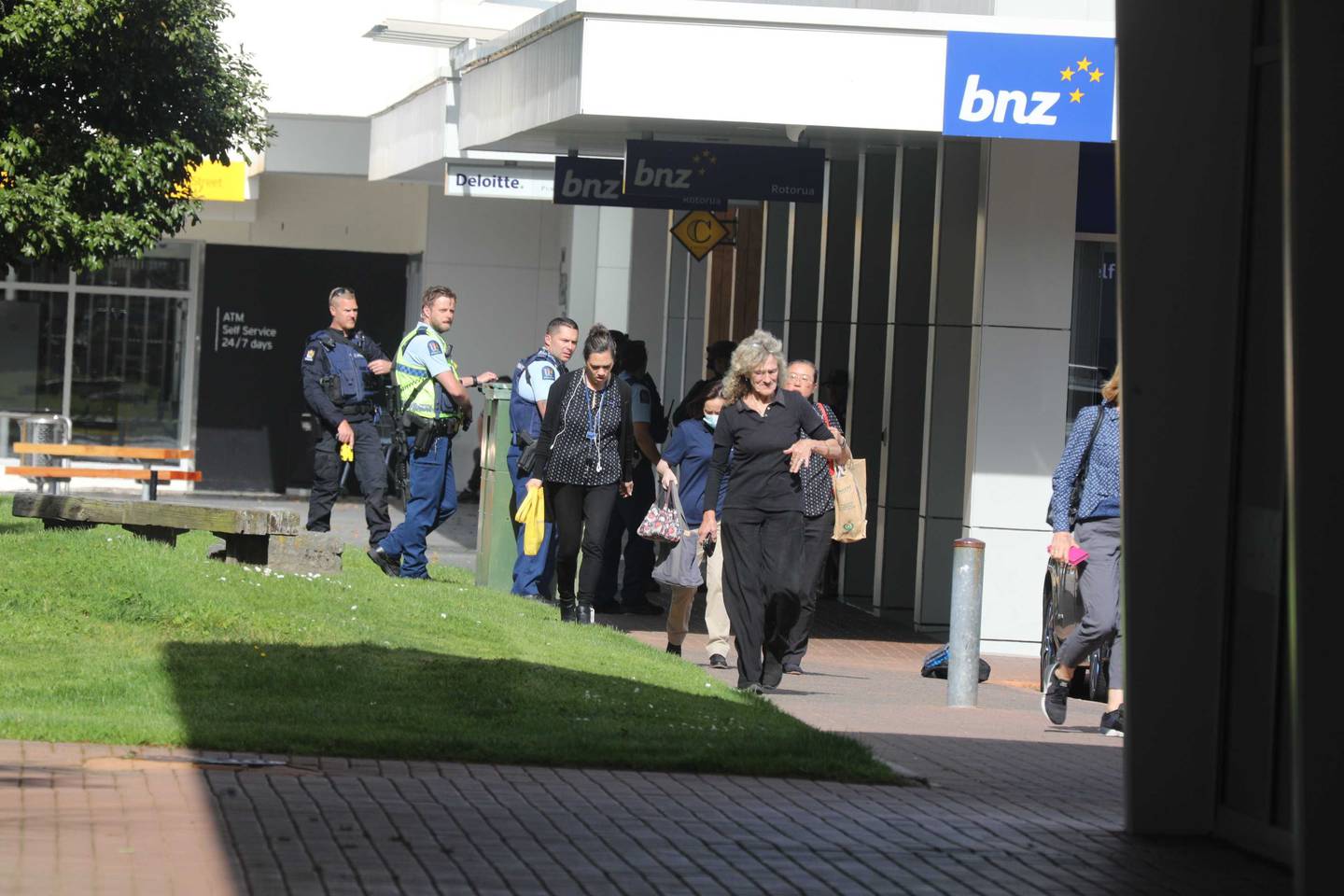 Customers and staff leaving the branch after being held hostage. Photo / Andrew Warner