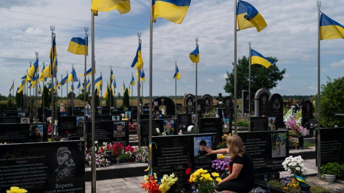 Svitlana, who wished to be identified by her first name only, touches the photo of her son, Vladyslav Cherniakov, at his grave in Bucha, Ukraine. Photo / AP