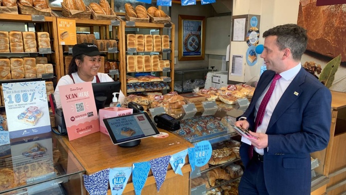 Act Party leader David Seymour speaks with a staffer at Bakers Delight during a walkabout in Remuera, Auckland. Photo / Adam Pearse