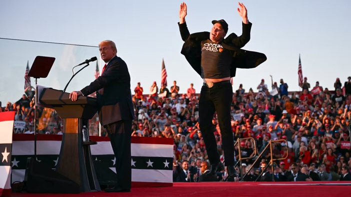Tesla CEO Elon Musk (right) jumps on stage as he joins Donald Trump (left) during a campaign rally at site of his first assassination attempt in Butler, Pennsylvania. Photo / AFP