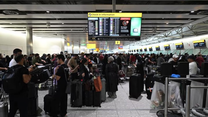 Travellers wait in terminal 4 at Heathrow Airport, west of London, after major European airports were hit by "cyber-related disruption". Photo / Justin Tallis, AFP