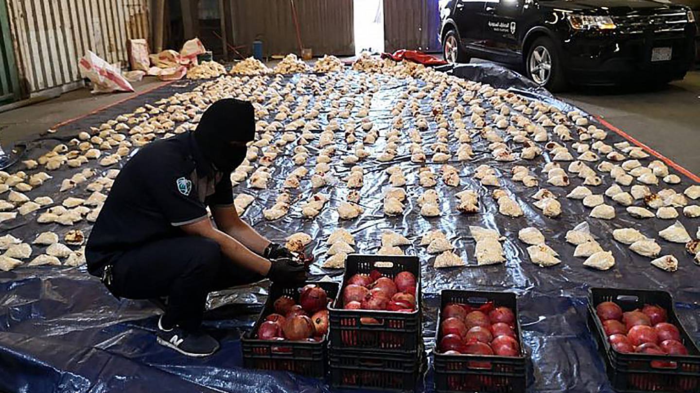 A Saudi customs officer opens imported pomegranates, as customs foiled an attempt to smuggle over five million pills of an amphetamine drug known as Captagon, which they said came from Lebanon, in 2021. Photo / Saudi Press Agency via AP