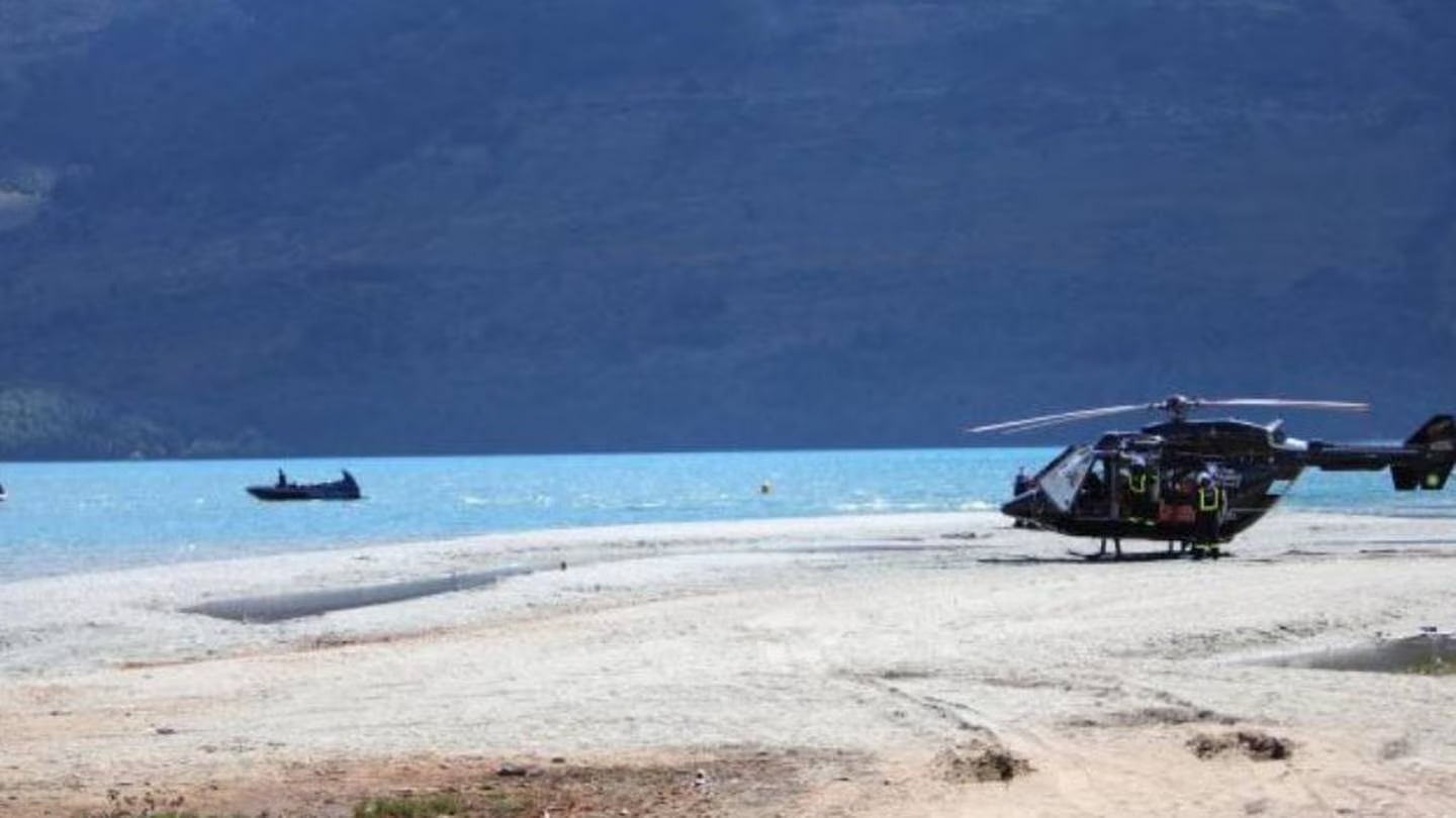 A rescue helicopter sits on a sandbar amid an emergency services response after a man went missing at Glenorchy Wharf trying to save someone else. Photo / Rhyva Van Onselen