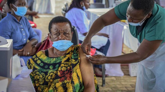 A woman receives a coronavirus vaccination at the Kololo airstrip in Kampala. (Photo / AP)