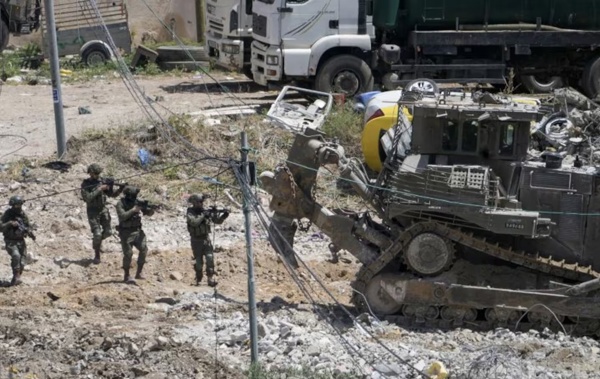 Israeli soliders aim their weapons during military operations in the town of Deir al-Ghusun, near the West Bank town of Tulkarem on May 4. (AP Photo/Majdi Mohammed)