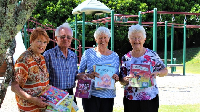 Y'vonne and John Miller with Pauline Donovan and Julie Tregear putting books out at Waikanae Park. Photo / Rosalie Willis