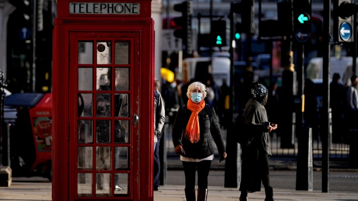 People wear face coverings as they walk through Westminster, in London, Thursday, Dec. 9, 2021. (Photo / AP)