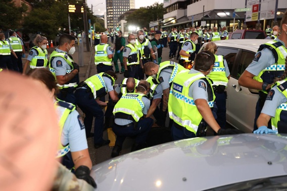 A white car has been driven into the crowd as Police armed with riot gear move in on the Wellington protest. (Photo / George Heard)