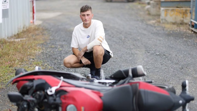 Matthew Burchell, pictured with his written-off Yamaha R3 motorcycle, nearly lost his left arm in a collision with a car last November. Photo / Michael Bradley