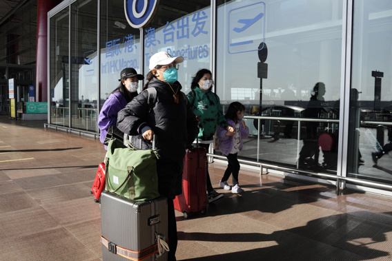 Passengers wearing masks walk through the Capital airport terminal in Beijing on Dec. 13, 2022. On Wednesday, Dec. 28, 2022, the U.S. announced new COVID-19 testing requirements for all travelers from China, joining other nations imposing restrictions because of a surge of infections.  Photo / AP