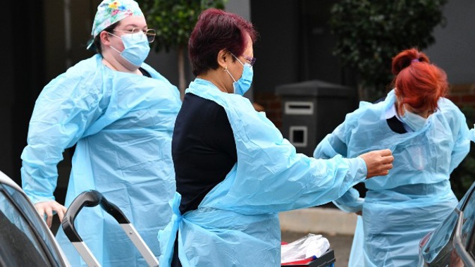 Healthcare workers don personal protective equipment before entering the Arcare Aged Care facility in Maidstone, Melbourne. (Photo / AAP)