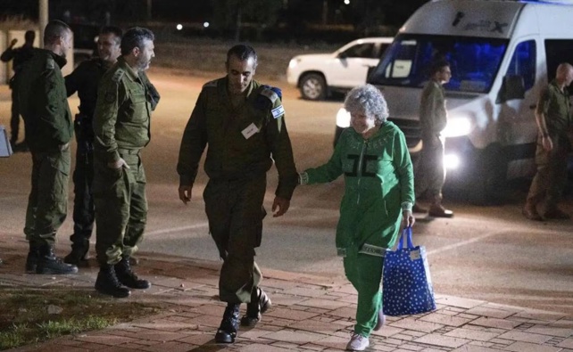 Ruth Munder, a released Israeli hostage, walks with an Israeli soldier shortly after her arrival in Israel on Friday. Photo / AP