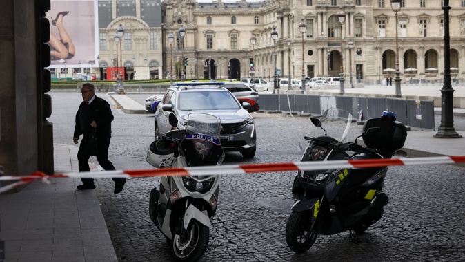 Police vehicles are seen as police officers stand guard outside the Louvre Museum as people are evacuated after it received a written threat, in Paris, Saturday Oct. 14, 2023. Photo / AP
