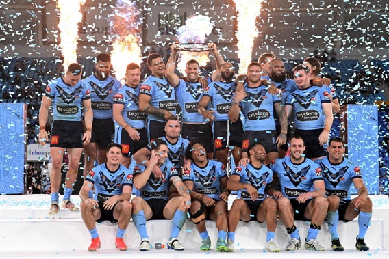 James Tedesco of the Blues holds aloft the Origin trophy and celebrates with teammates after winning the series 2-1. (Photo / Getty)