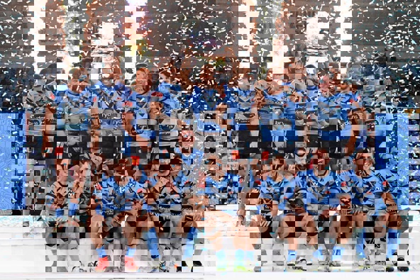 James Tedesco of the Blues holds aloft the Origin trophy and celebrates with teammates after winning the series 2-1. (Photo / Getty)