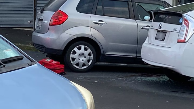 A car with a smashed window at the driver's seat could be seen in the police cordon at the homicide scene in Mt Wellington. Photo / Isaac Davison.