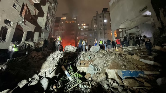 Lebanese civil defence members and other people inspect the site of an Israeli airstrike on the Basta neighbourhood of Beirut on Friday. Photo / AFP