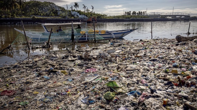 A boat docks at a beach filled with plastic waste at Freedom Island in Paranaque, the Philippines.