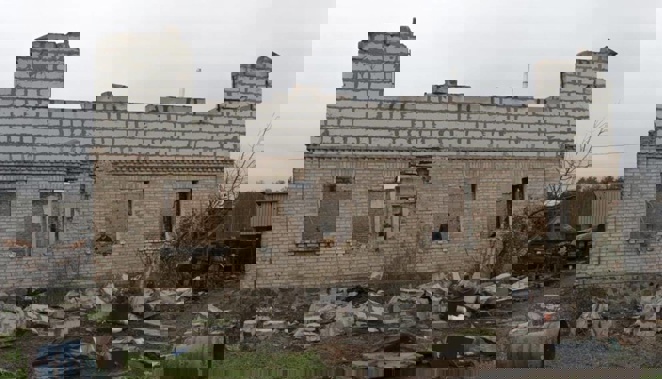 Vadym, 59, is seen in a window of his destroyed house in the village of Moshun, outside Kyiv, Ukraine. Photo / AP