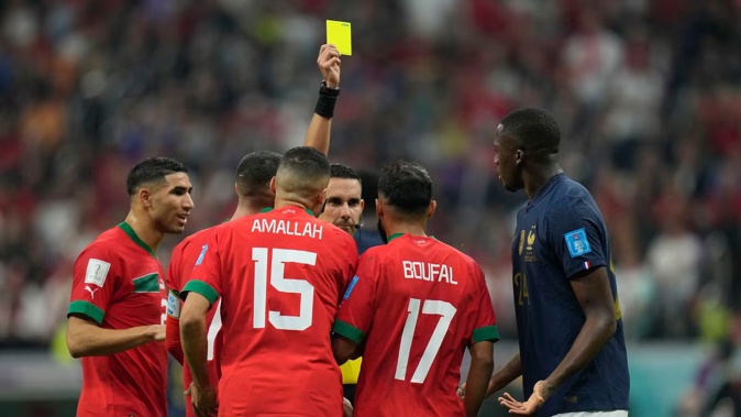 Referee Cesar Ramos is confronted by players as he shows a yellow card to Morocco's Sofiane Boufal during last year's World Cup semifinal match against France. Photo / AP