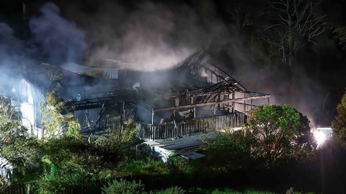 The fire completely destroyed the house on Red Hills Rd in Massey. Photo / Hayden Woodward