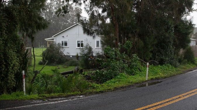 Four teens were hurt - two critically - after their vehicle crashed off the Coatesville-Riverhead Highway in West Auckland and came to rest upside down against this house. Photo / Hayden Woodward